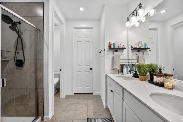 a bathroom with a double vanity sink mirror and shower