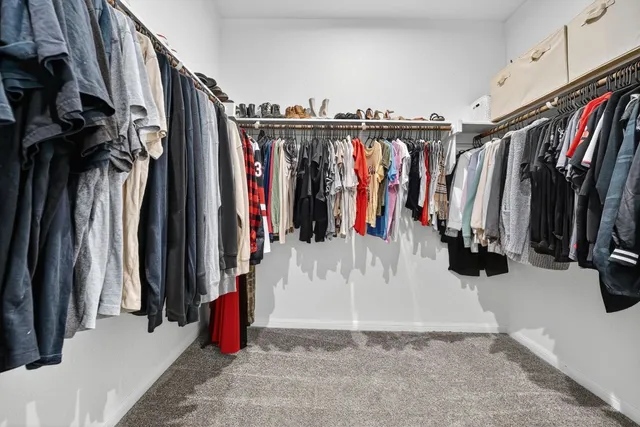 a view of walk in closet with clothes and shoes