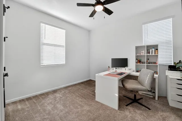 a view of a workspace with furniture and a window