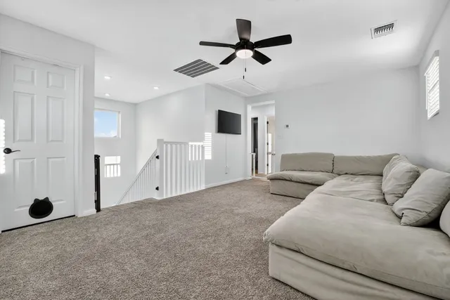 a living room with furniture and a ceiling fan
