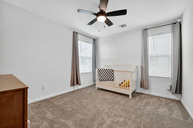 an empty room with a ceiling fan and wooden floor
