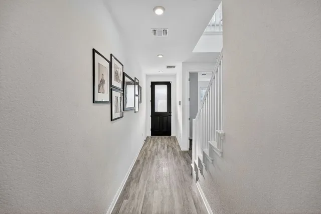 a view of a hallway with wooden floor and staircase
