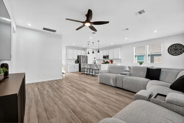 a living room with furniture and kitchen view