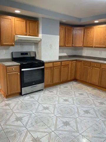 a kitchen with granite countertop a stove a sink and a microwave