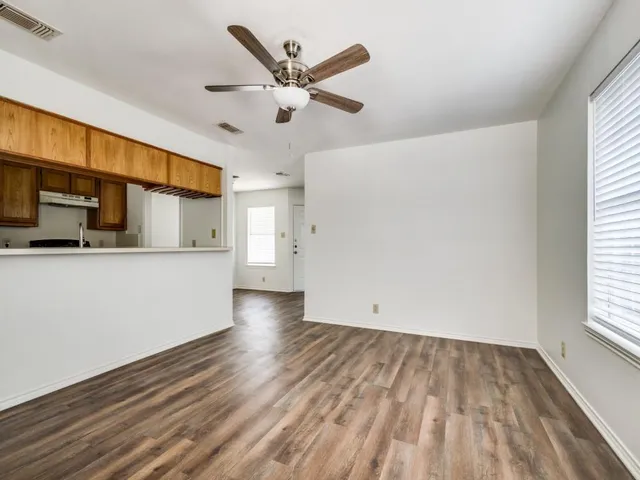 a view of a kitchen with wooden floor and a ceiling fan