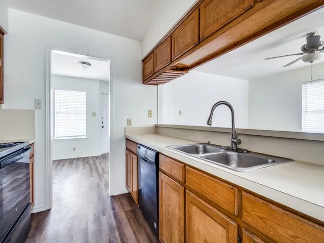 a kitchen with a sink a faucet cabinets and appliances