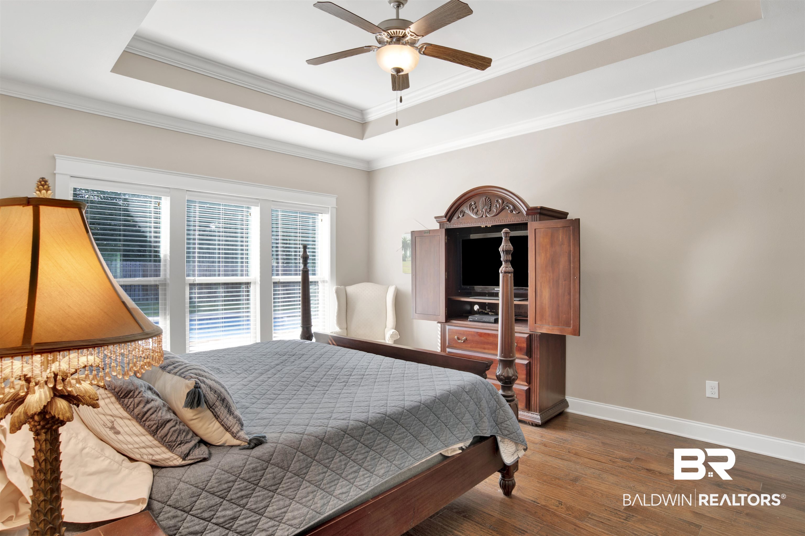 360 Scarlett Avenue Fairhope, AL 36532 - Photo 24 of 34 Bedroom with ornamental molding, a tray ceiling, dark wood-type flooring, and ceiling fan