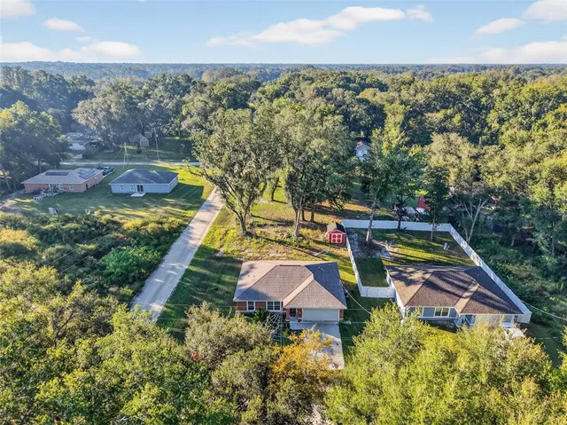 an aerial view of a house with a yard and lake view