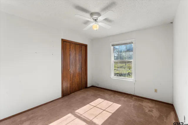 a bathroom with a granite countertop sink a toilet a mirror and shower
