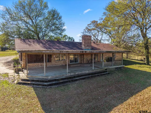 a view of a house with a yard yard and tree