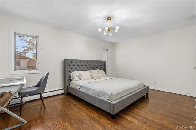 a bedroom with a bed paintings on the wall and a window