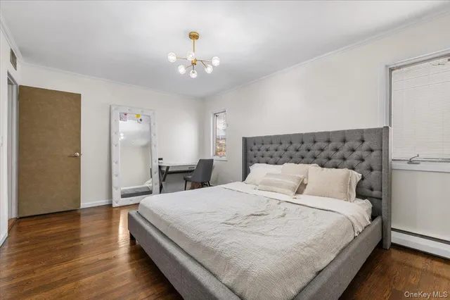 a bedroom with a large bed and wooden floor