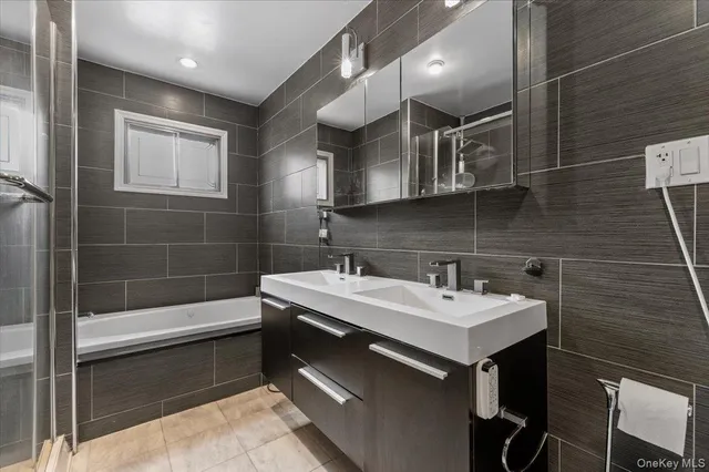 a bathroom with a sink a toilet a mirror and bathtub