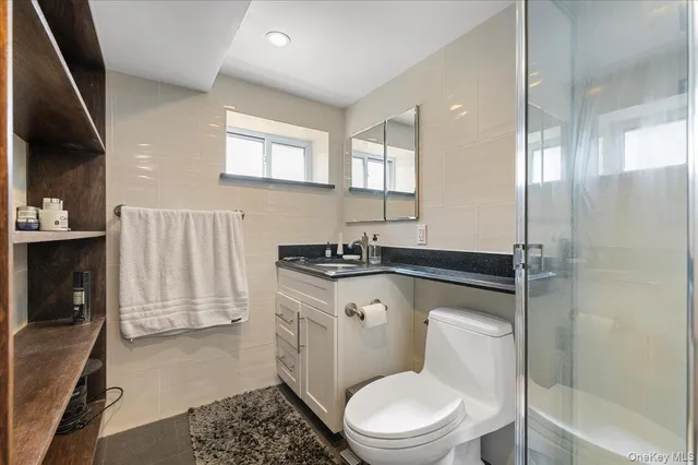 a bathroom with a toilet a sink and glass door