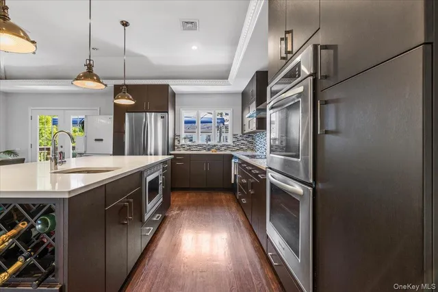 a kitchen with stainless steel appliances granite countertop a sink and a refrigerator