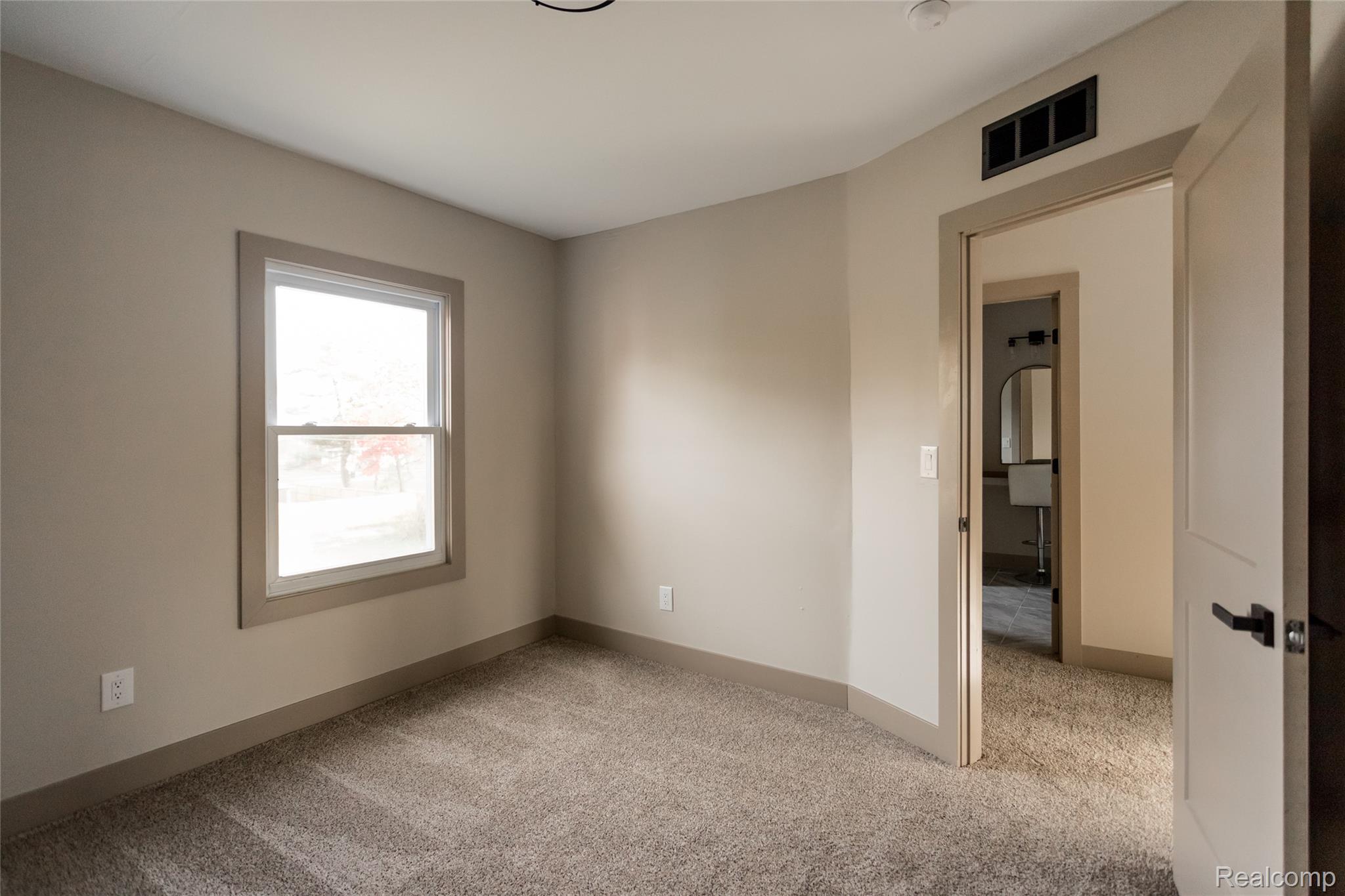 2630 Harding Street Detroit, MI 48214 - Photo 27 of 30 Neutral-toned wall paint and trim, soft carpet flooring, and a double-hung window