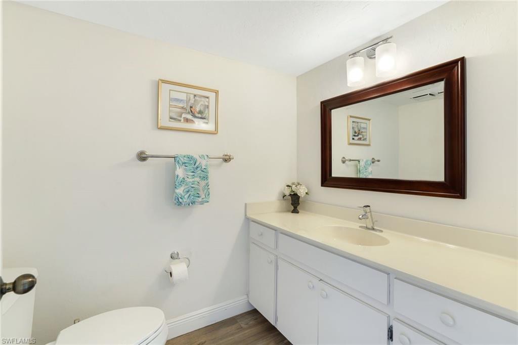 1510 Imperial Golf Course Boulevard, Unit 111 Naples, FL 34110 - Photo 11 of 21 a bathroom with a toilet sink and mirror