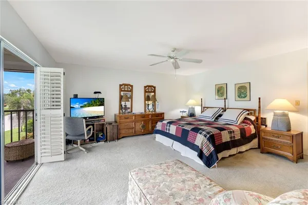 a spacious bedroom with a bed a desk and chair