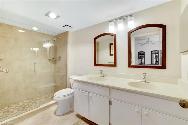 a bathroom with a double vanity sink toilet and shower
