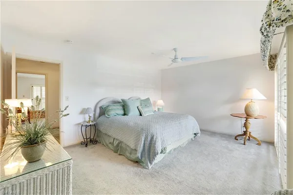 a spacious bedroom with a bed and a lamp
