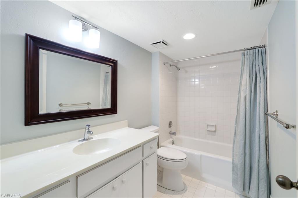 1510 Imperial Golf Course Boulevard, Unit 111 Naples, FL 34110 - Photo 17 of 21 a bathroom with a toilet sink and mirror