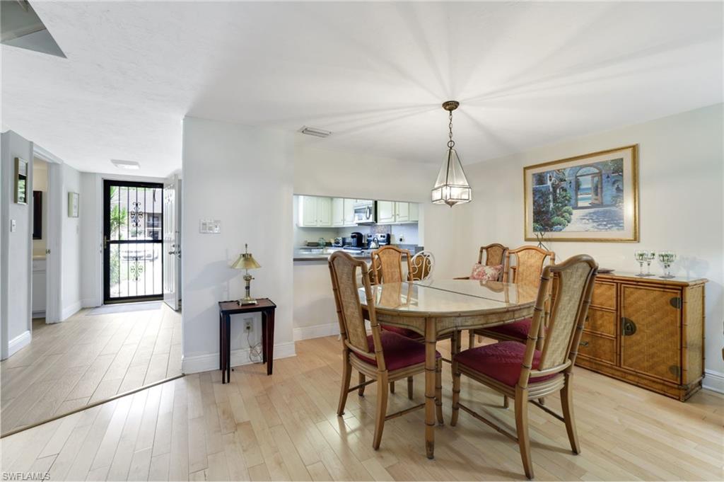 1510 Imperial Golf Course Boulevard, Unit 111 Naples, FL 34110 - Photo 8 of 21 a view of a dining room with furniture window and wooden floor