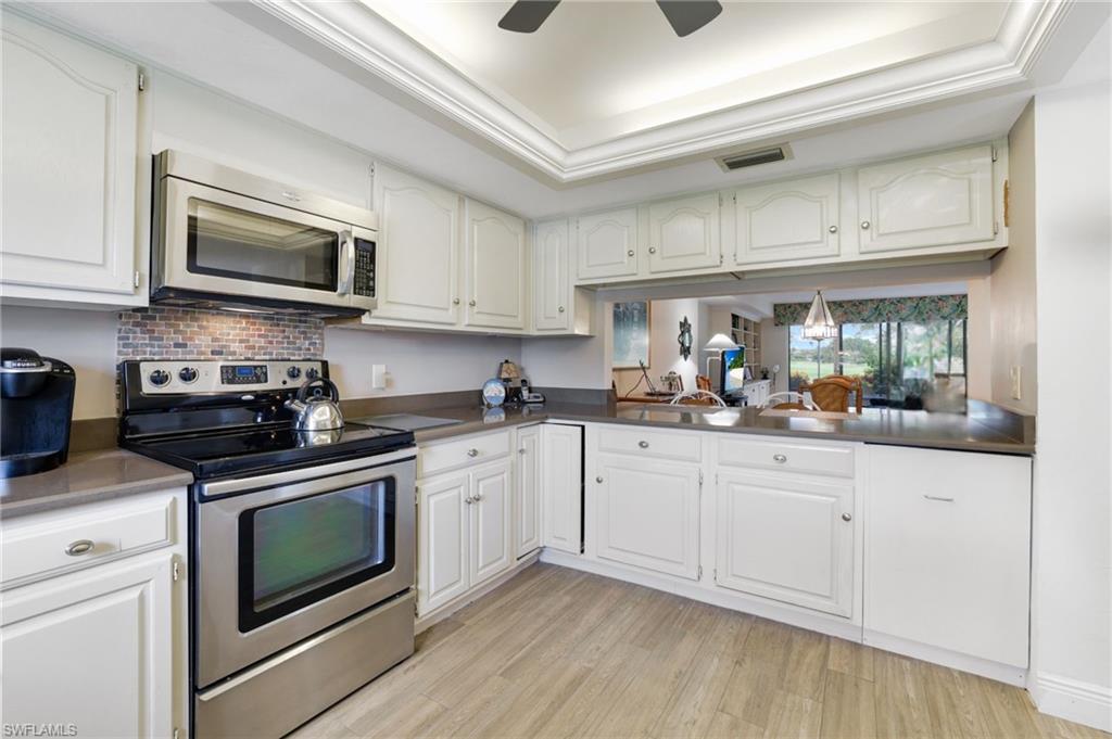 1510 Imperial Golf Course Boulevard, Unit 111 Naples, FL 34110 - Photo 9 of 21 a kitchen with stainless steel appliances granite countertop a sink and a stove