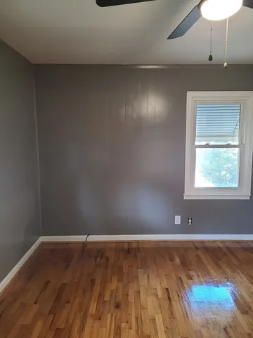 a view of room with wooden floor and fan