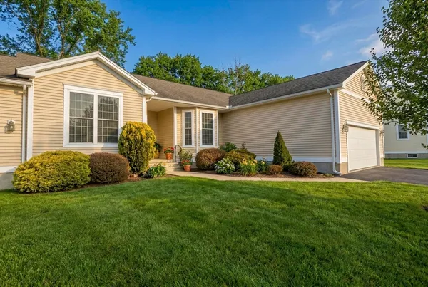 a view of a house with a patio and a yard