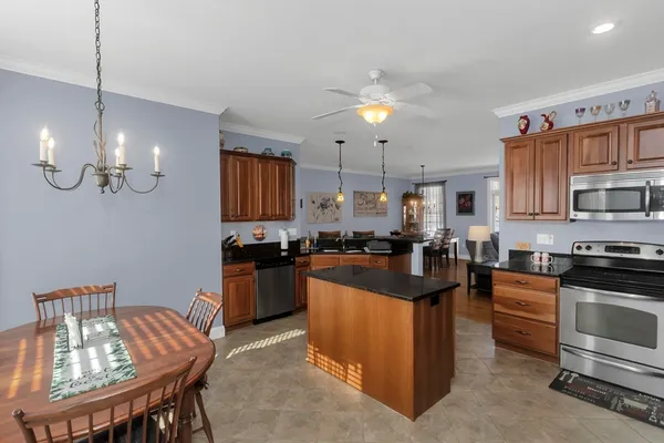 a kitchen with stainless steel appliances granite countertop a stove top oven a sink dishwasher and a refrigerator