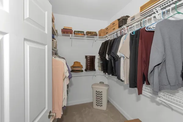 a view of walk in closet with clothes and shoes