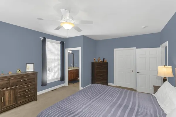 a view of a bedroom with wooden floor cabinet and a bed
