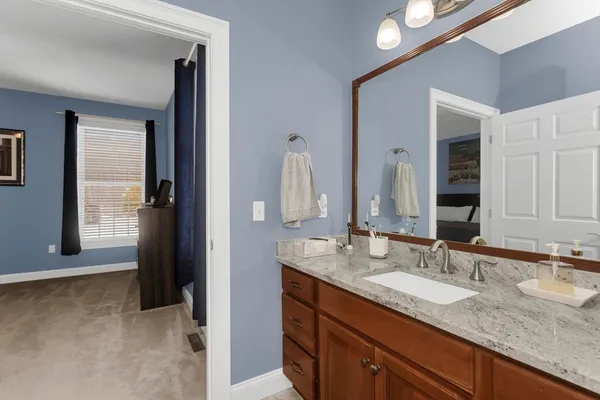 a bathroom with a granite countertop sink and a mirror