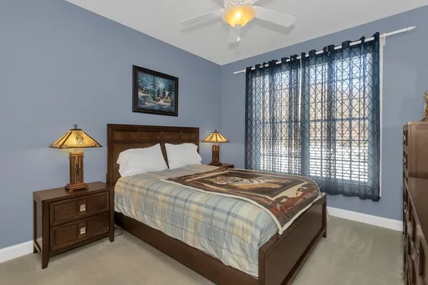 a bedroom with a bed and a lamp on dresser