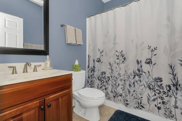 a bathroom with a granite countertop sink and a toilet