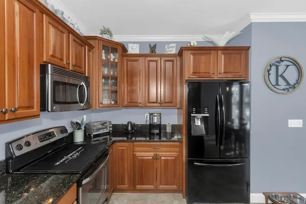 a kitchen with granite countertop stainless steel appliances and wooden cabinets