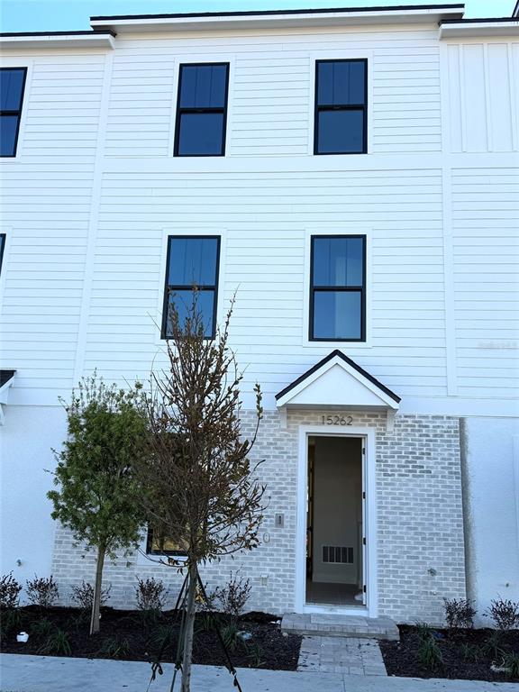 a brick house with a small yard and a large window