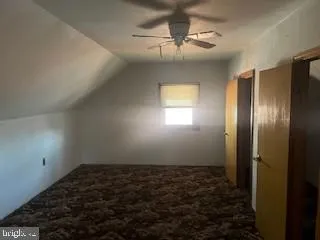en empty room with windows and ceiling fan