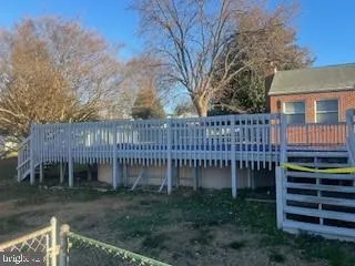 a view of a house with a yard and a wooden deck