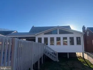 a view of a house with wooden deck and furniture