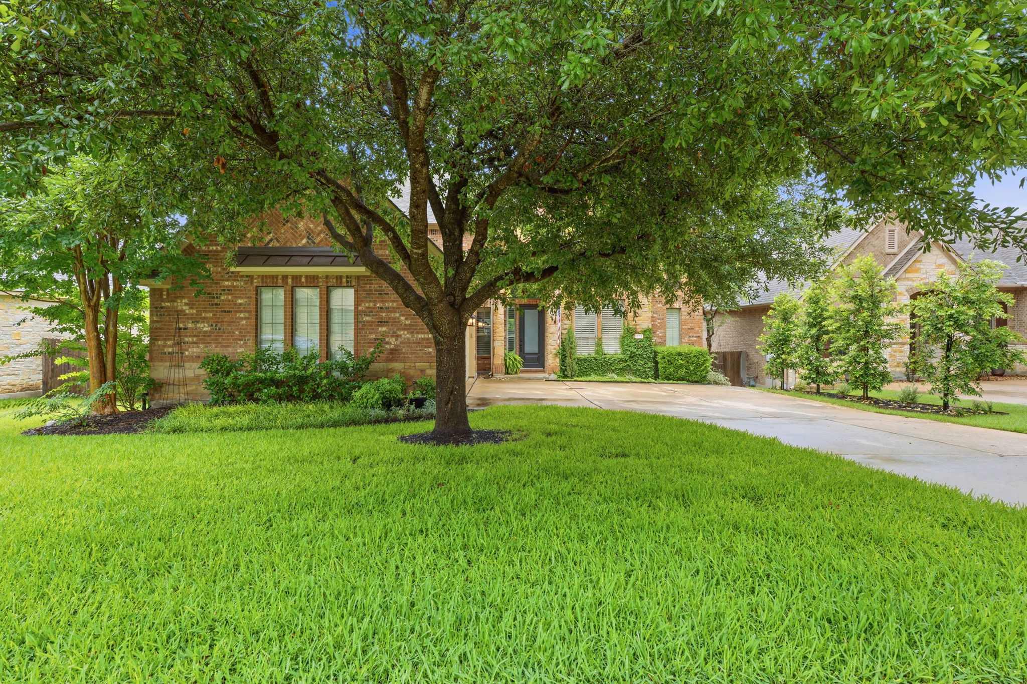 12321 Edenvale Path Austin, TX 78732 - Photo 2 of 36 A traditional brick home with mature trees and a well-kept front lawn welcomes you.