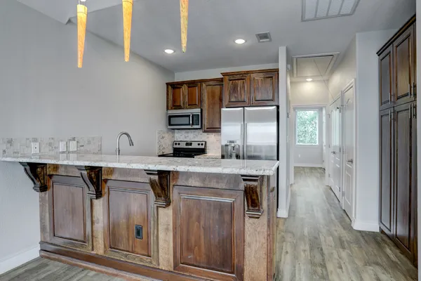 a kitchen with stainless steel appliances granite countertop a sink a stove and a refrigerator