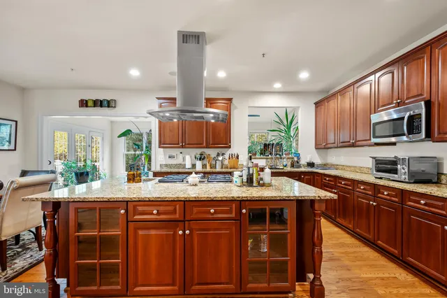 a kitchen with stainless steel appliances granite countertop wooden cabinets a stove and a sink