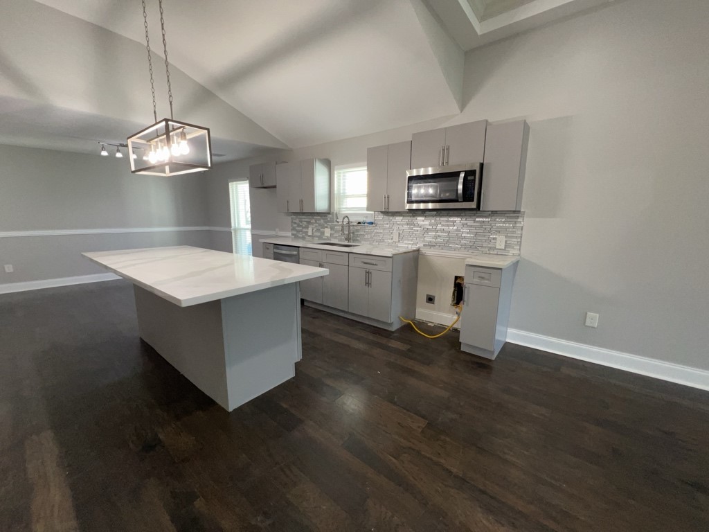 401 Walton Street Houston, TX 77009 - Photo 12 of 27 a open kitchen with stainless steel appliances granite countertop a sink dishwasher stove and microwave with wooden floor