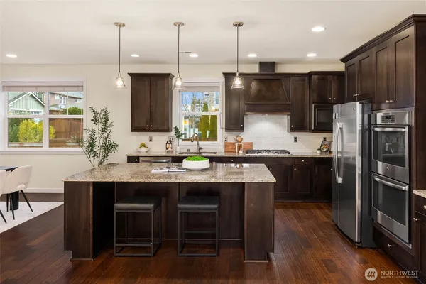 a kitchen with stainless steel appliances granite countertop a sink refrigerator and cabinets