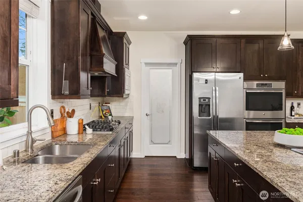 a kitchen with granite countertop a sink a stove and refrigerator
