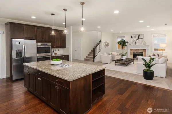 a kitchen with kitchen island a counter top space a sink appliances and cabinets