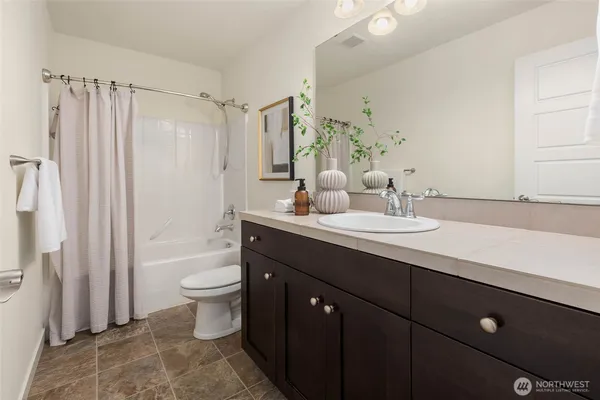 a bathroom with a double vanity sink toilet and shower