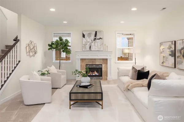a living room with furniture a potted plant and a fireplace
