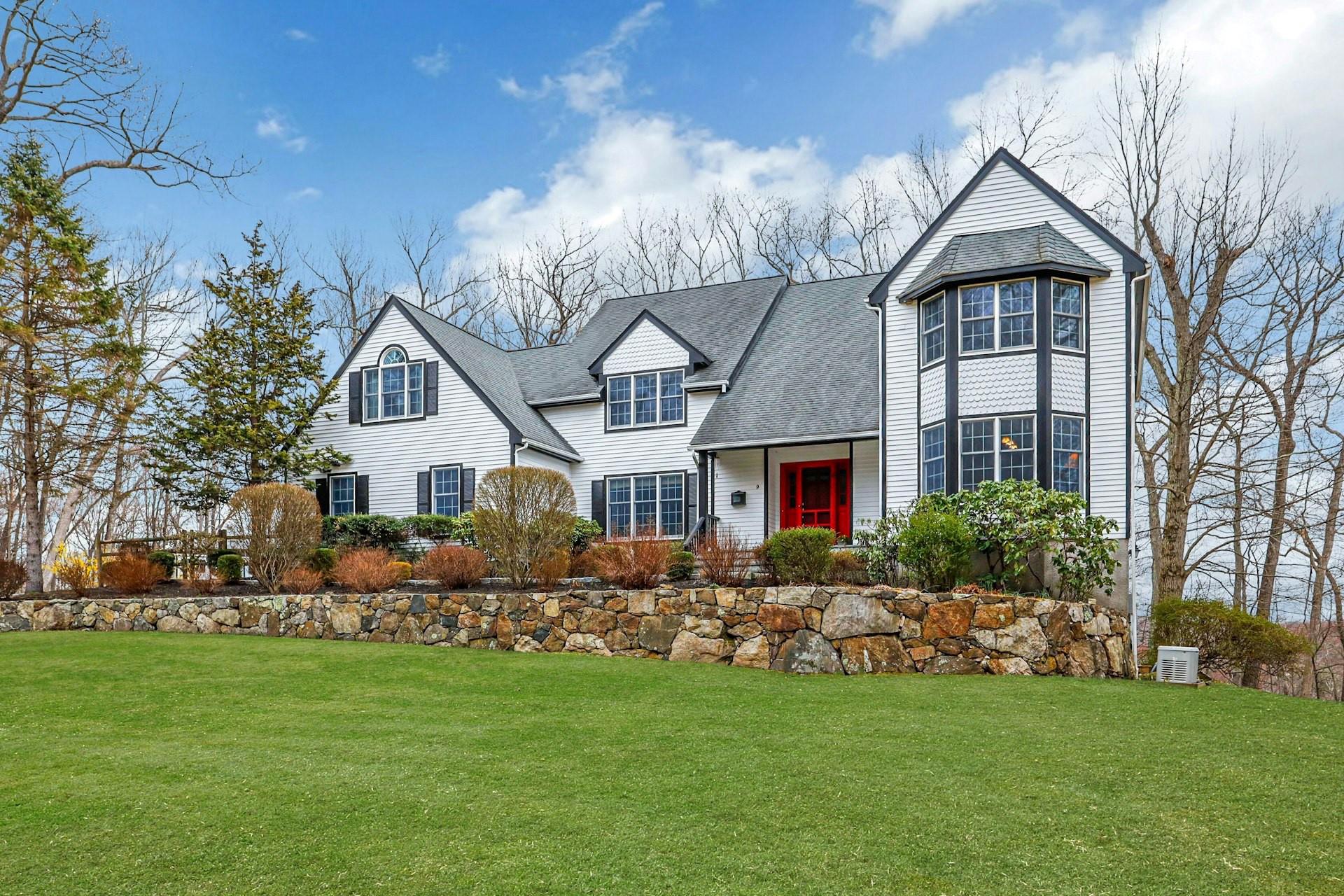 View of front of property featuring a shingled roof and a front lawn